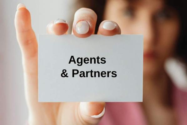 A lady holding a card with the text 'Agents and Partners'